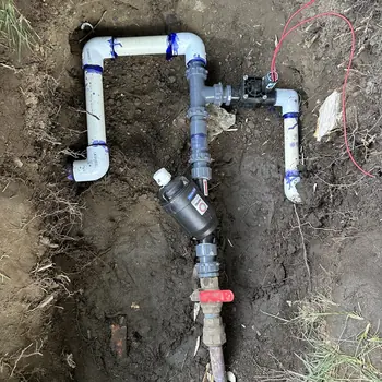 Freshly assembled PVC valve manifold and piping in an open trench